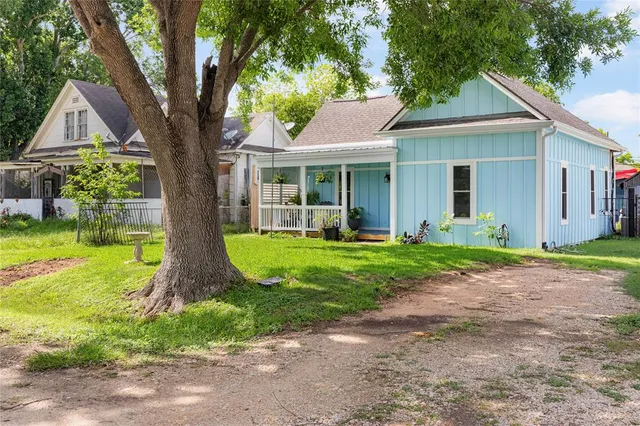 a view of a house with a yard and palm trees