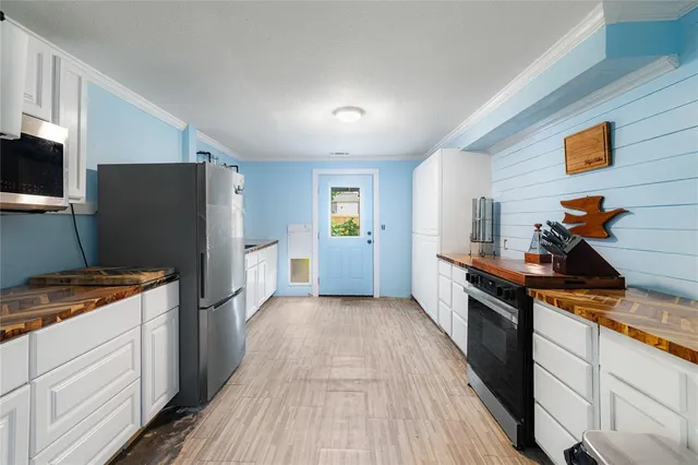 a kitchen with stainless steel appliances granite countertop a sink and wooden floor