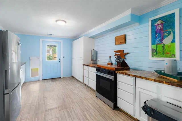 a kitchen with a refrigerator cabinets and wooden floor