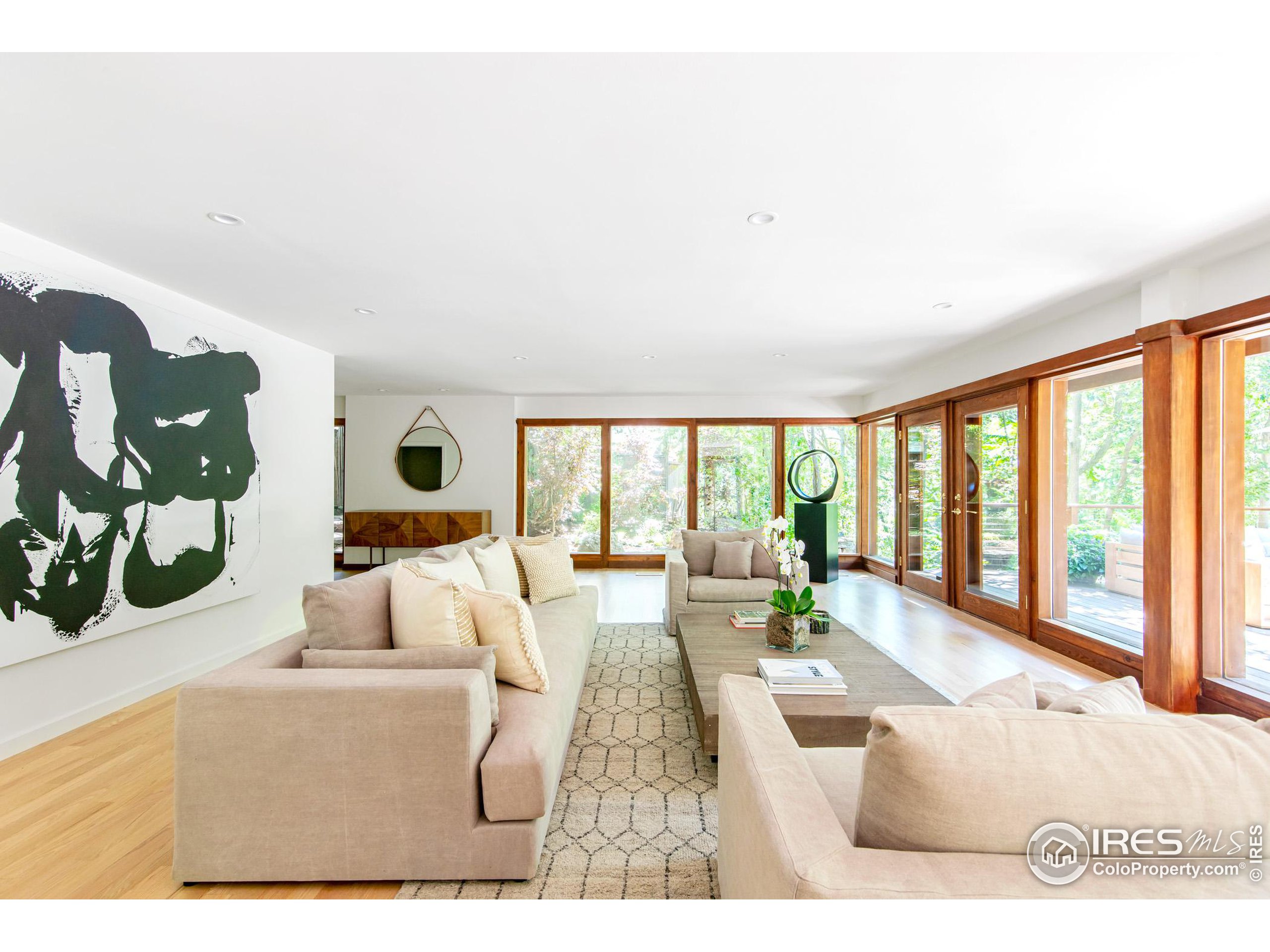 2323 4th Street Boulder, CO 80302 - Photo 10 of 40 a living room with furniture large windows a rug and white walls