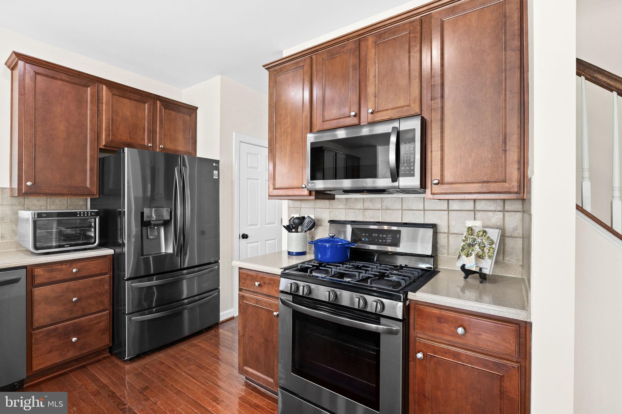 4185 Agency Loop Triangle, VA 22172 - Photo 14 of 46 a kitchen with granite countertop wooden cabinets stainless steel appliances and a window