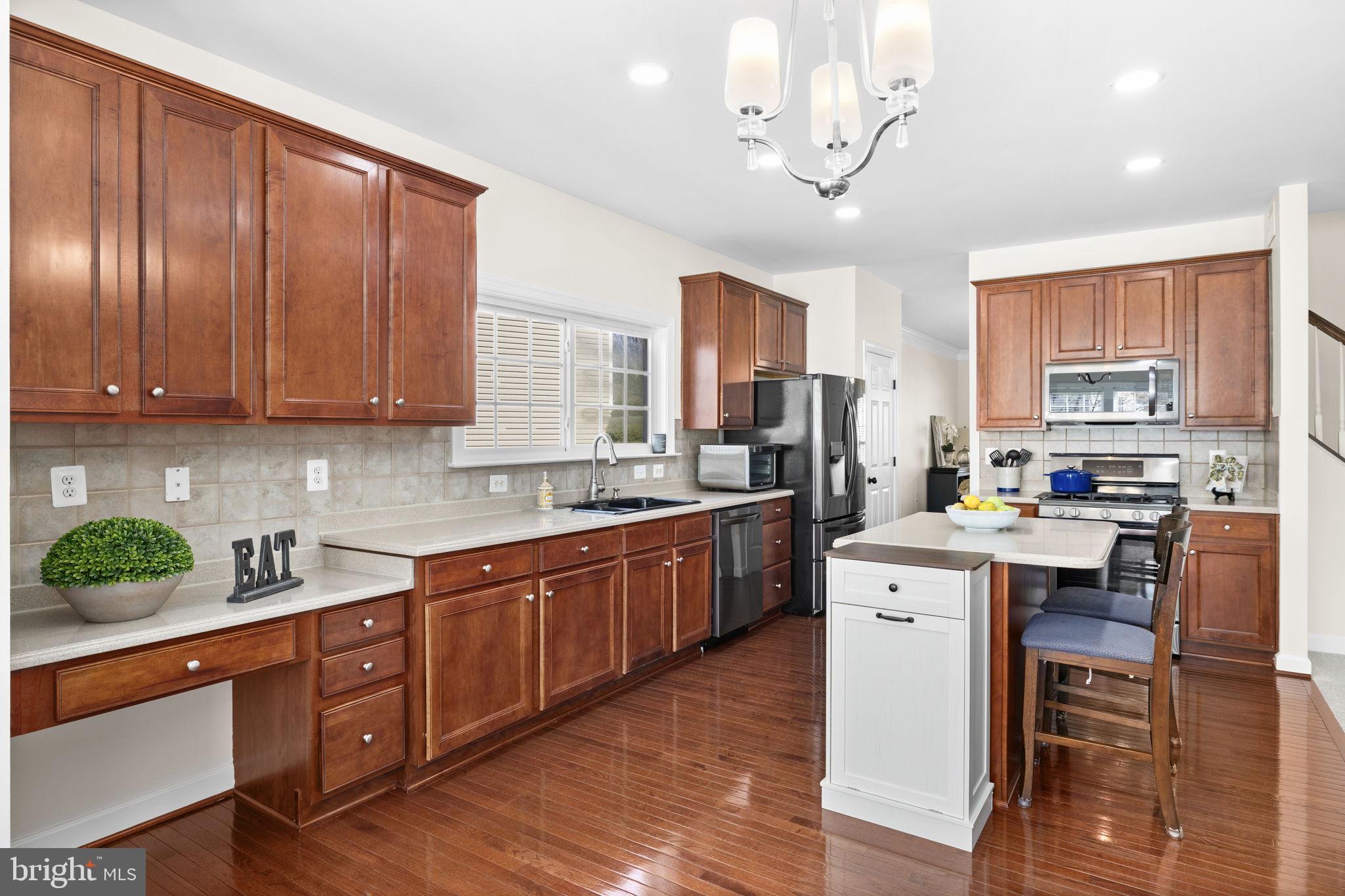 4185 Agency Loop Triangle, VA 22172 - Photo 16 of 46 a kitchen with stainless steel appliances granite countertop wooden cabinets a dining table and chairs