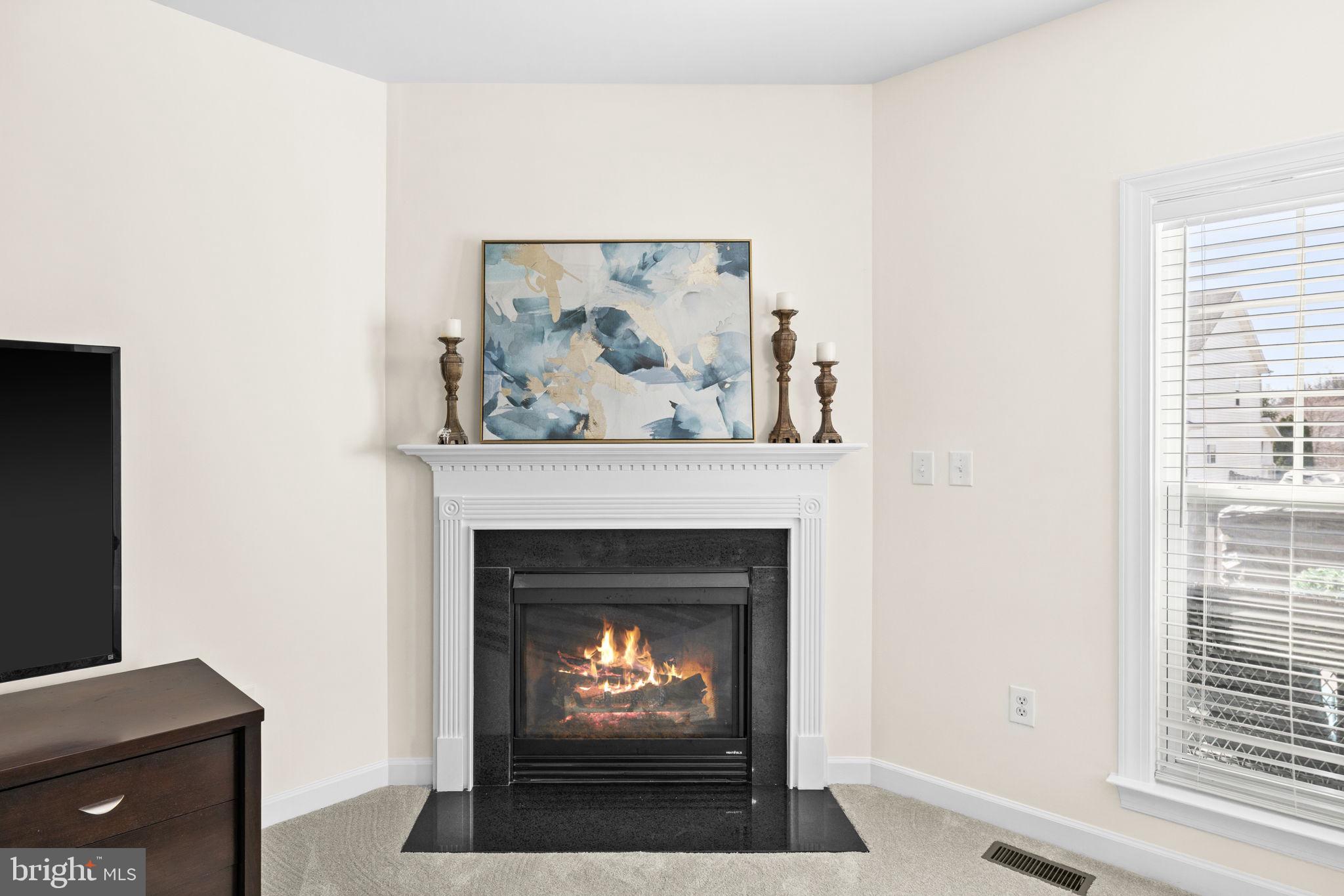 4185 Agency Loop Triangle, VA 22172 - Photo 21 of 46 a living room with a fireplace and a painting on the wall