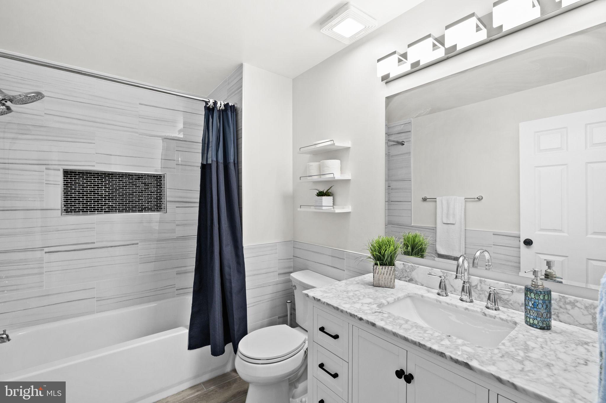 4185 Agency Loop Triangle, VA 22172 - Photo 40 of 46 a bathroom with a granite countertop sink a mirror a bathtub and shower