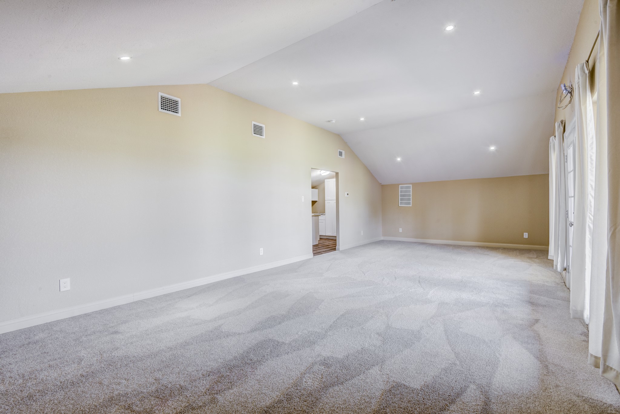 7348 Love Road Fulshear, TX 77441 - Photo 38 of 48 Spacious room with vaulted ceilings and recessed lighting, featuring plush carpeting and abundant natural light from large windows.