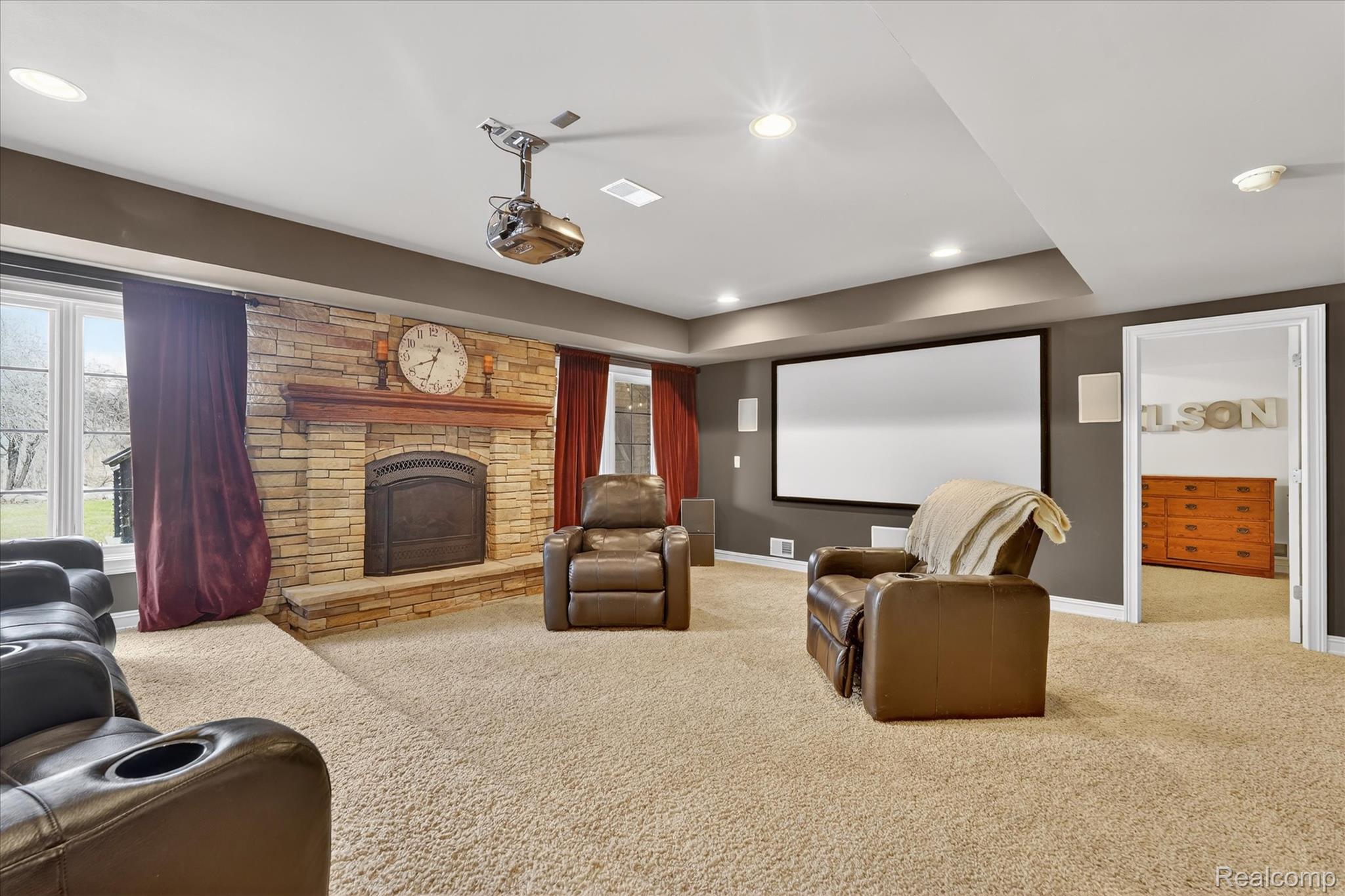 6932 Oakhurst Ridge Road Clarkston, MI 48348 - Photo 47 of 78 Home theater room with carpet floors, a stone fireplace, recessed lighting, and plenty of natural light