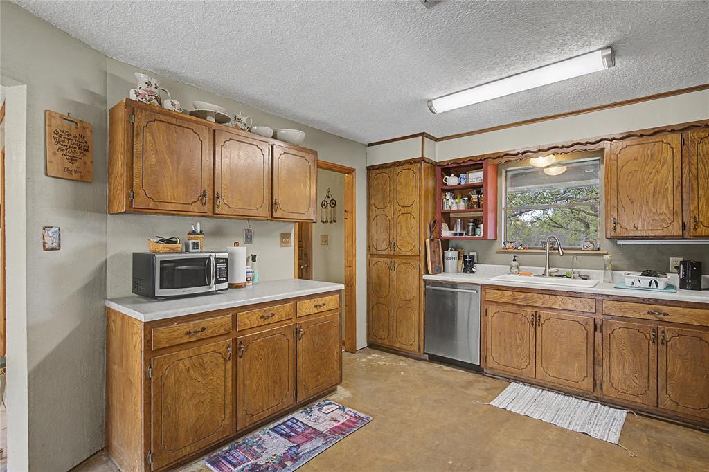 243 County Road 3851 Poolville, TX 76487 - Photo 15 of 34 a kitchen with a sink stove and refrigerator