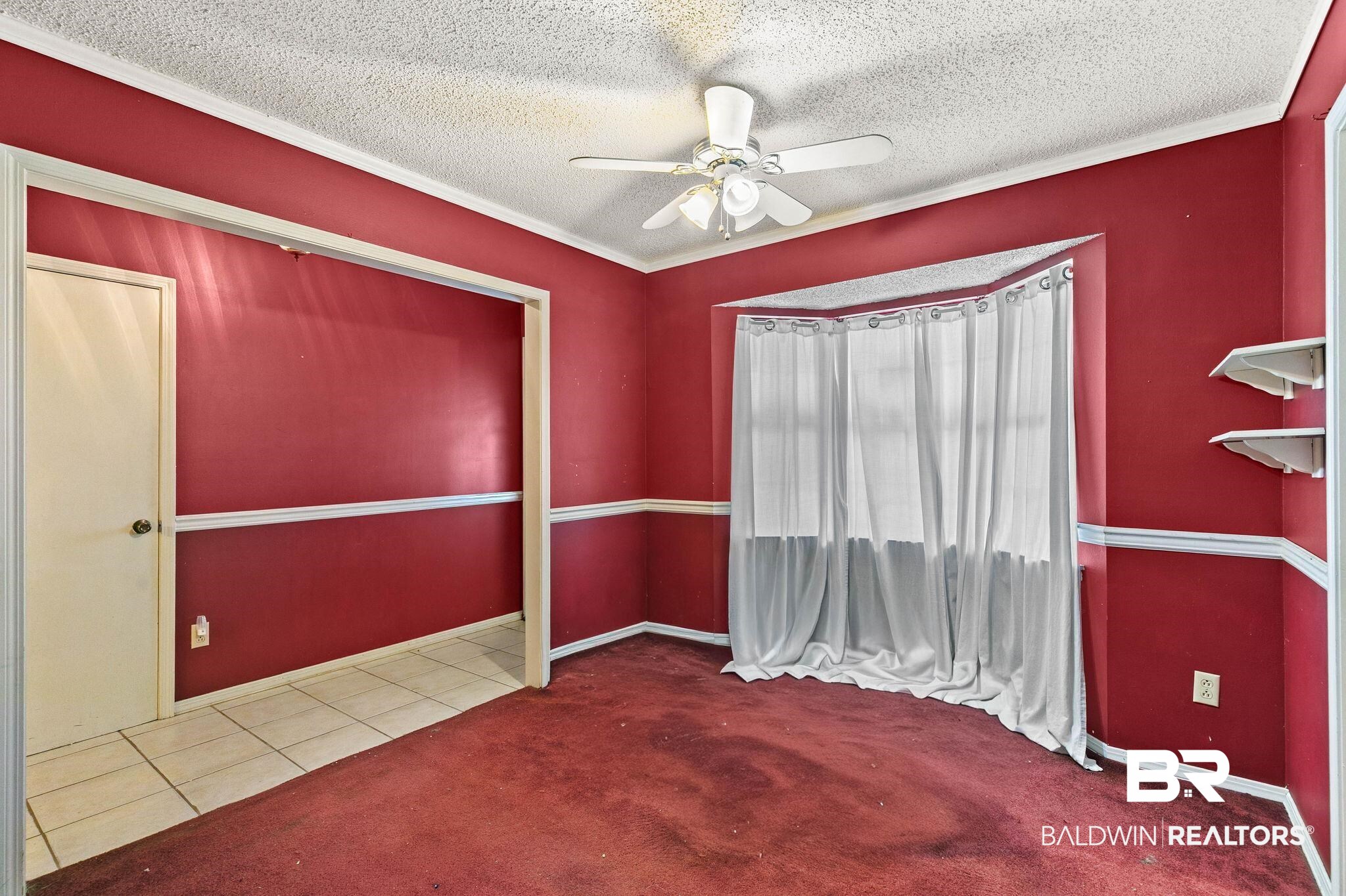 13653 Roberts Road Loxley, AL 36551 - Photo 8 of 33 Interior room featuring a ceiling fan, bay window, white trim, and a doorway opening to a tiled area