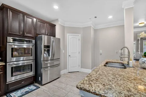 a kitchen with stainless steel appliances granite countertop a refrigerator and a stove top oven
