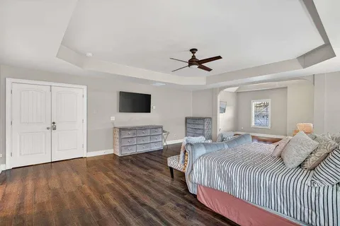 a bedroom with a large bed a flat tv screen and dresser