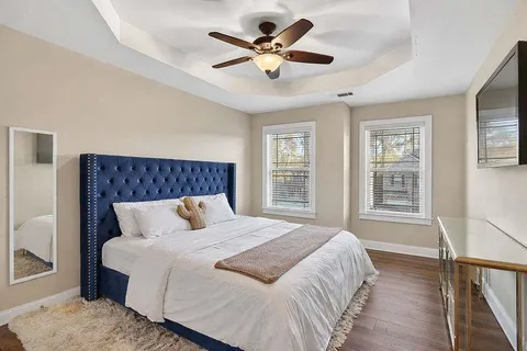 a bedroom with a large bed and a chandelier