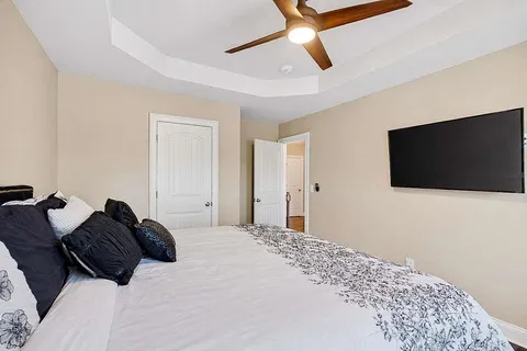 a bedroom with a large bed and a flat screen tv