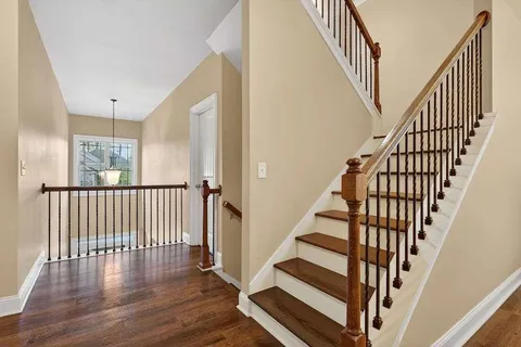 a view of staircase with wooden floor and white walls