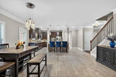 a view of a dining room and livingroom with furniture wooden floor a chandelier