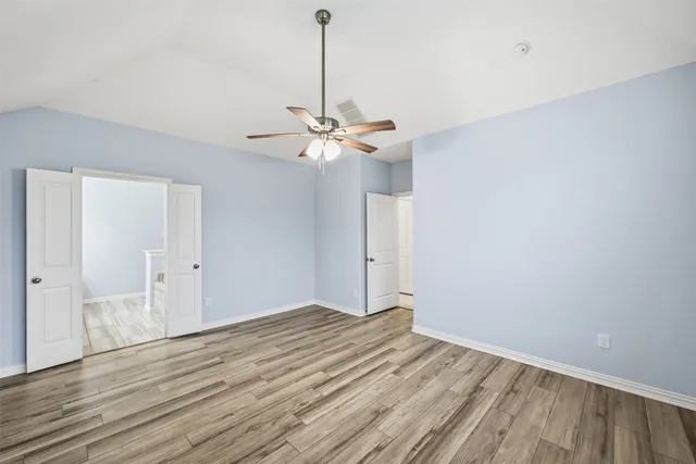 a view of a room with a ceiling fan and wooden floor