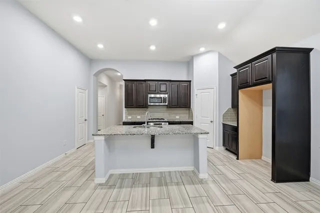 a kitchen with stainless steel appliances a sink and a refrigerator