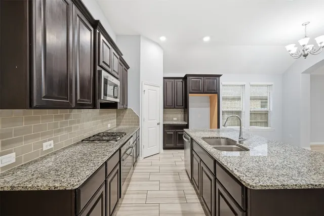 a kitchen with stainless steel appliances granite countertop a sink stove and refrigerator