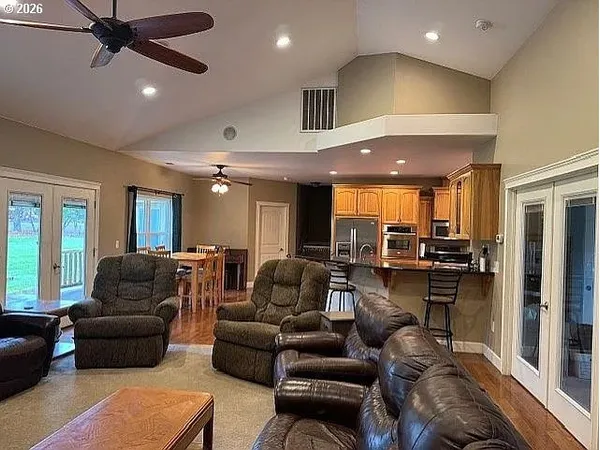 a living room with furniture kitchen view and a large window