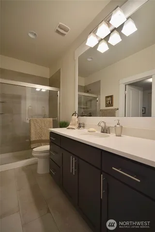 a bathroom with a double vanity sink toilet and shower