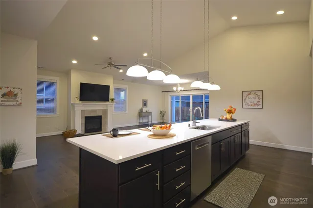 a kitchen with a sink and a stove top oven with wooden floor