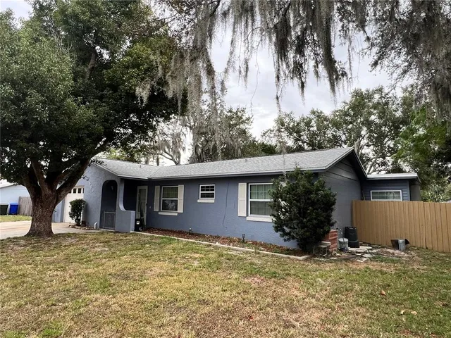 a front view of house with yard and trees around