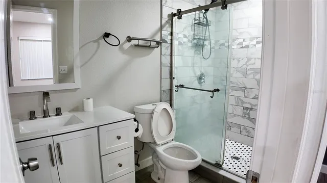 a bathroom with a granite countertop sink toilet and shower