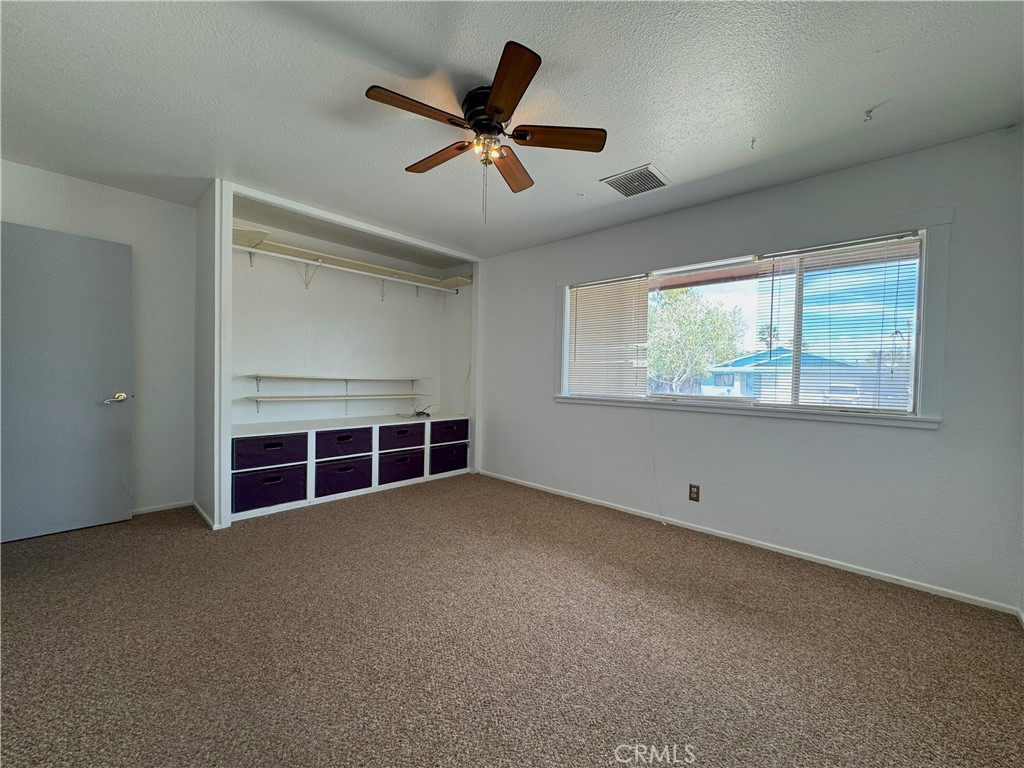 543 Weiman Avenue Ridgecrest, CA 93555 - Photo 13 of 37 an empty room with windows and ceiling fan