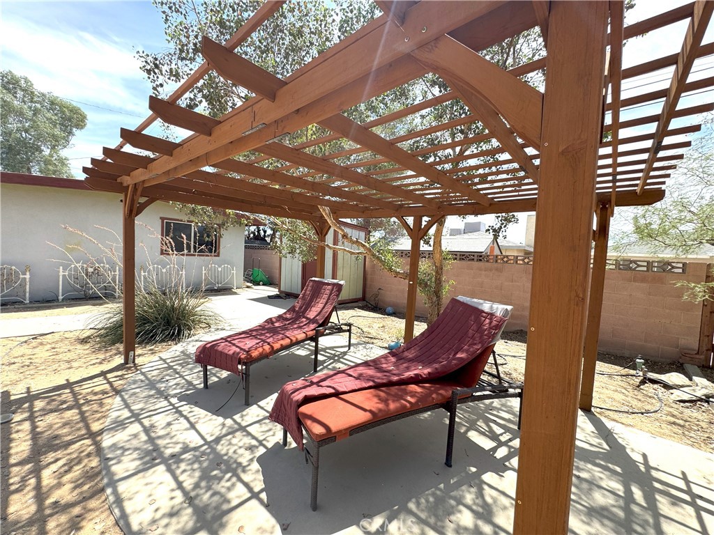 543 Weiman Avenue Ridgecrest, CA 93555 - Photo 26 of 37 a view of a patio with table and chairs and floor to ceiling window