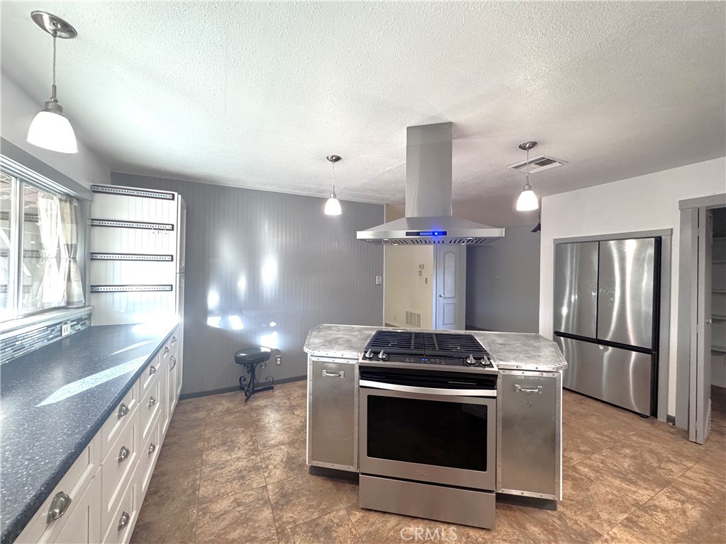 543 Weiman Avenue Ridgecrest, CA 93555 - Photo 34 of 37 a kitchen with stainless steel appliances a stove a sink and a refrigerator