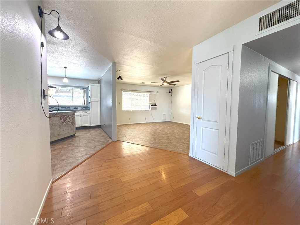 543 Weiman Avenue Ridgecrest, CA 93555 - Photo 7 of 37 a view of a hallway with wooden floor and a living room