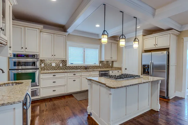 a kitchen with granite countertop stove cabinets and stainless steel appliances