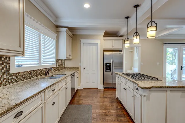 a kitchen with granite countertop a sink stove and cabinets