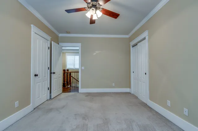 a view of an empty room with a chandelier fan