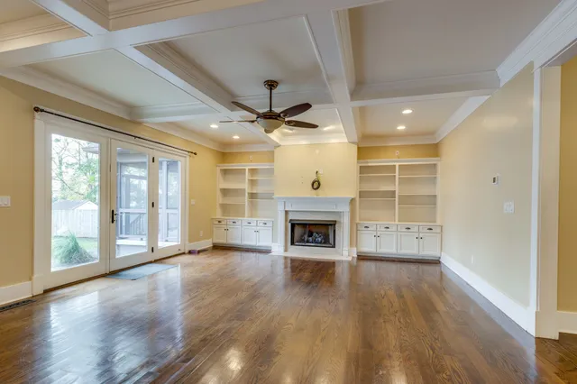 a view of an empty room with a fireplace and a window