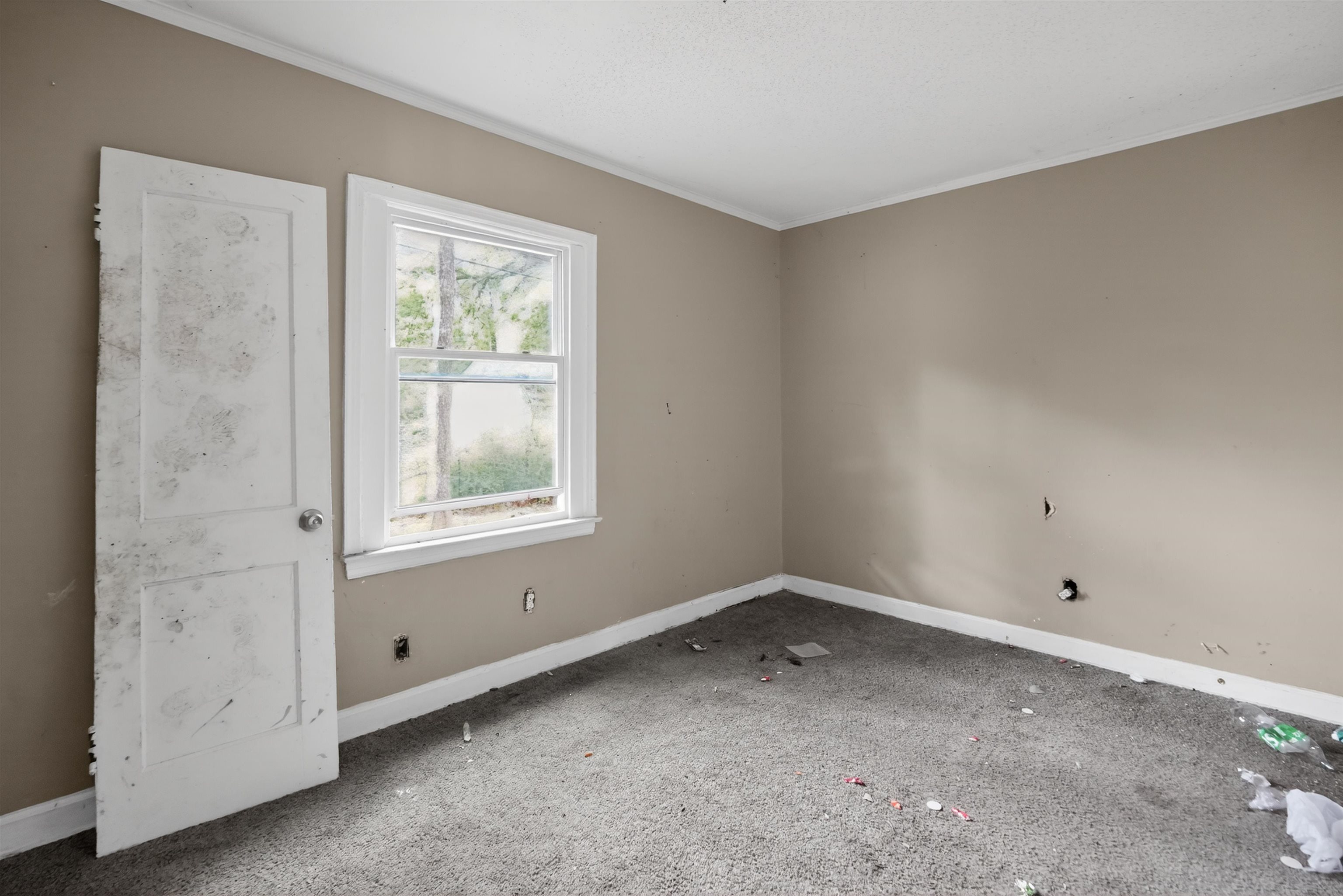 949 Sumter Street Memphis, TN 38122 - Photo 15 of 33 Room featuring a double-hung window with white trim, tan wall paint, and white baseboards