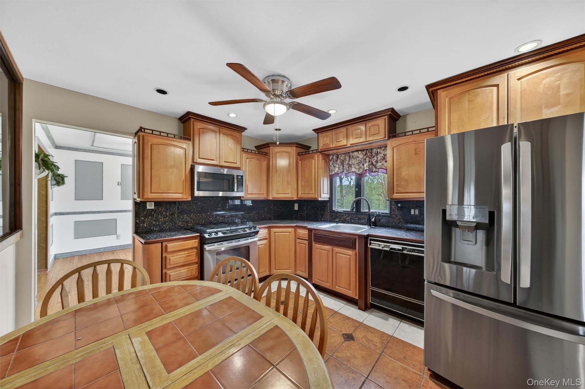 155 Pine Tree Road Monroe, NY 10950 - Photo 13 of 49 a kitchen with stainless steel appliances granite countertop a refrigerator a stove a sink a dining table and chairs with wooden floor