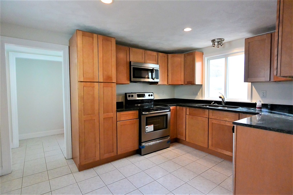 6 Arnold Road Peabody, MA 01960 - Photo 2 of 24 a kitchen with granite countertop a refrigerator and a sink