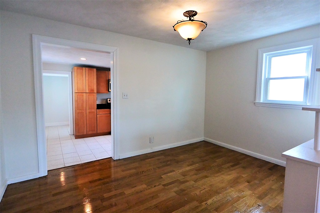 6 Arnold Road Peabody, MA 01960 - Photo 6 of 24 a view of an empty room with wooden floor and a window