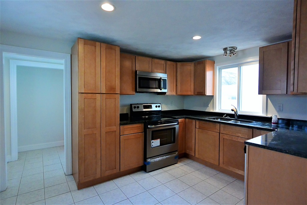 6 Arnold Road Peabody, MA 01960 - Photo 8 of 24 a kitchen with granite countertop a refrigerator and a stove top oven