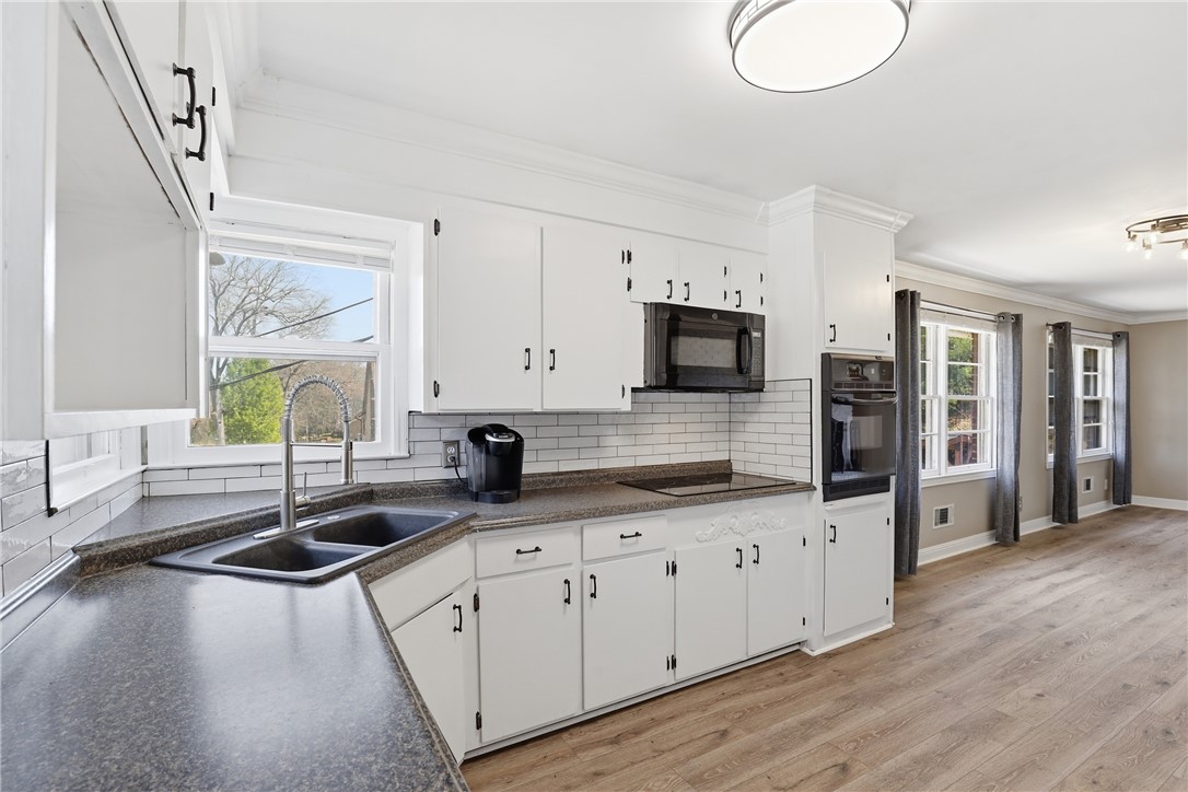 4304 Old Buncombe Road Greenville, SC 29617 - Photo 11 of 49 This bright kitchen features white cabinetry and modern appliances, perfect for everyday living.