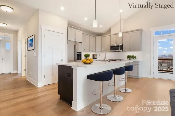 a kitchen with stainless steel appliances kitchen island granite countertop a sink a refrigerator and a stove