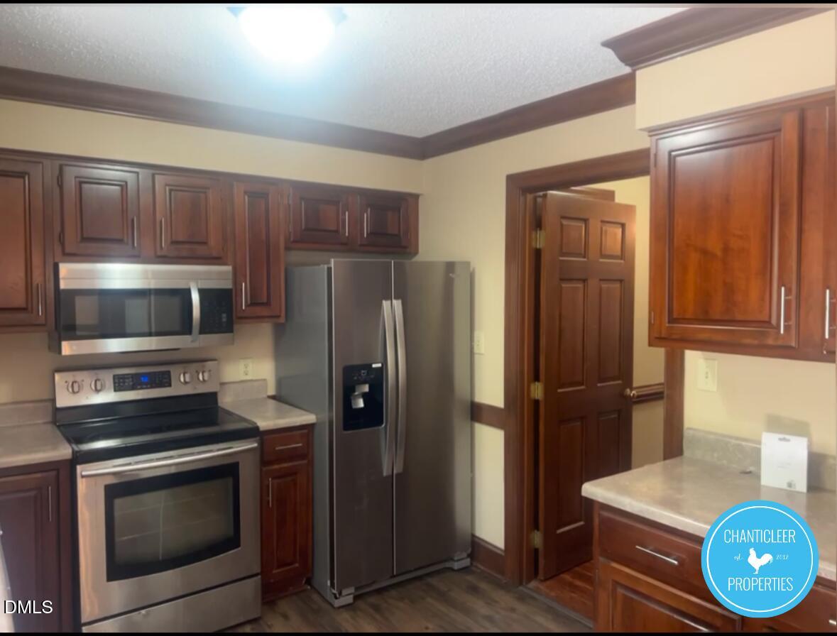 6923 Sandringham Drive Raleigh, NC 27613 - Photo 4 of 16 a kitchen with a refrigerator stove and microwave