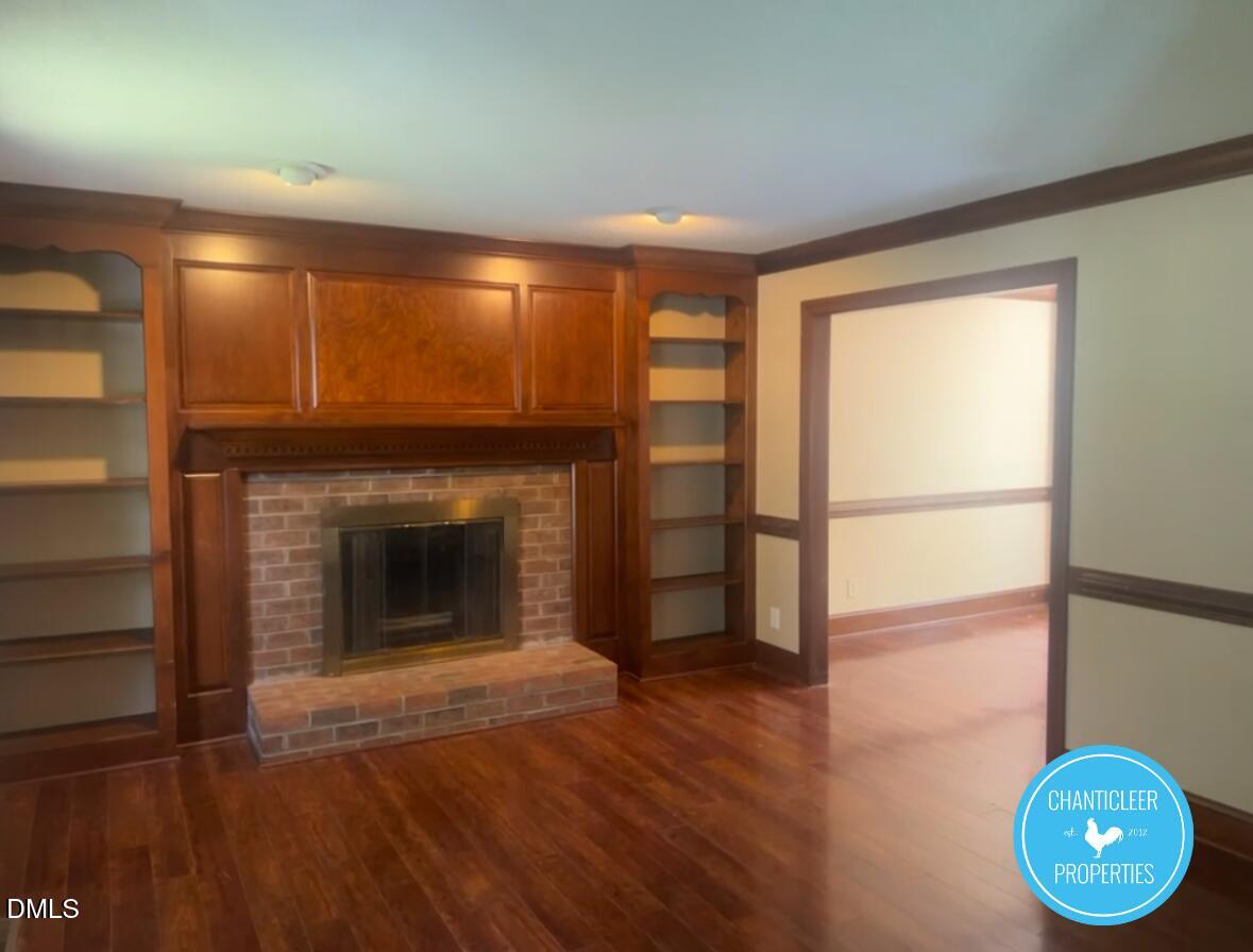 6923 Sandringham Drive Raleigh, NC 27613 - Photo 5 of 16 a view of an empty room with wooden floor and a window