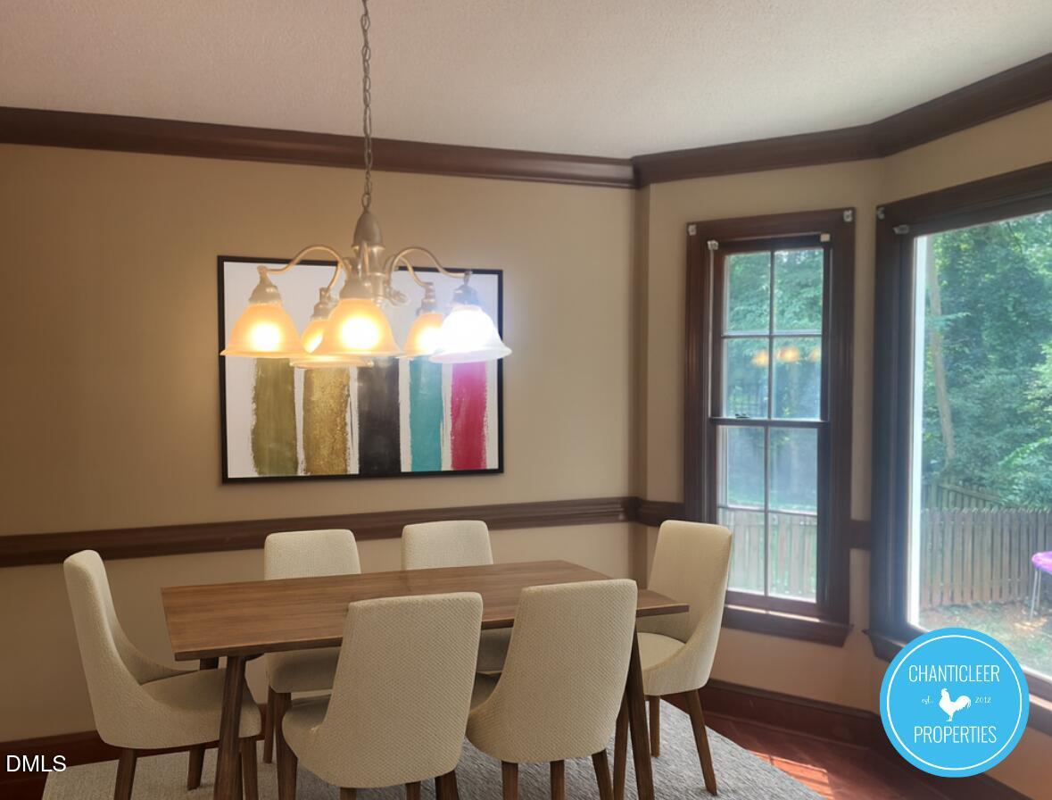 6923 Sandringham Drive Raleigh, NC 27613 - Photo 7 of 16 a view of a dining room with furniture wooden floor and chandelier