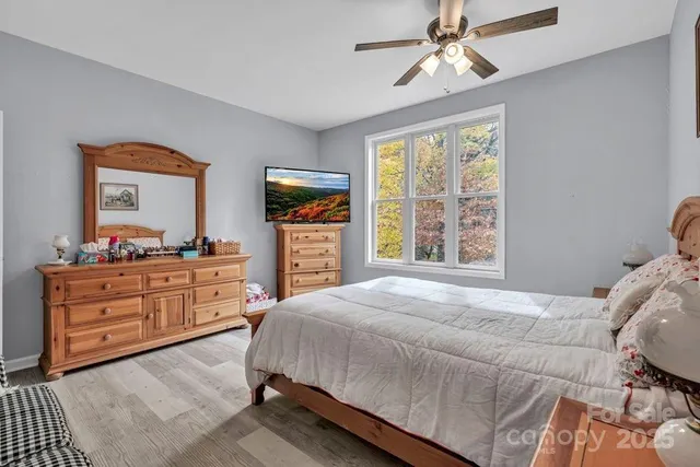 a bathroom with a granite countertop sink a toilet a large mirror and a window