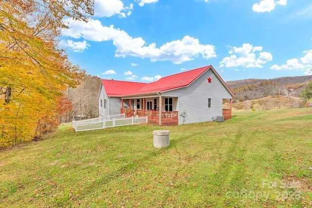a view of a house with pool and a yard