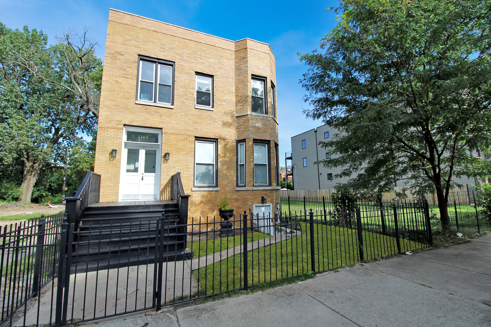 5169 South Michigan Avenue, Unit 2 Chicago, IL 60615 - Photo 1 of 21 a view of a house with a small yard and plants
