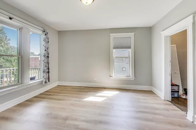 a view of an empty room with glass door and windows