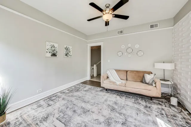a living room with furniture and a ceiling fan
