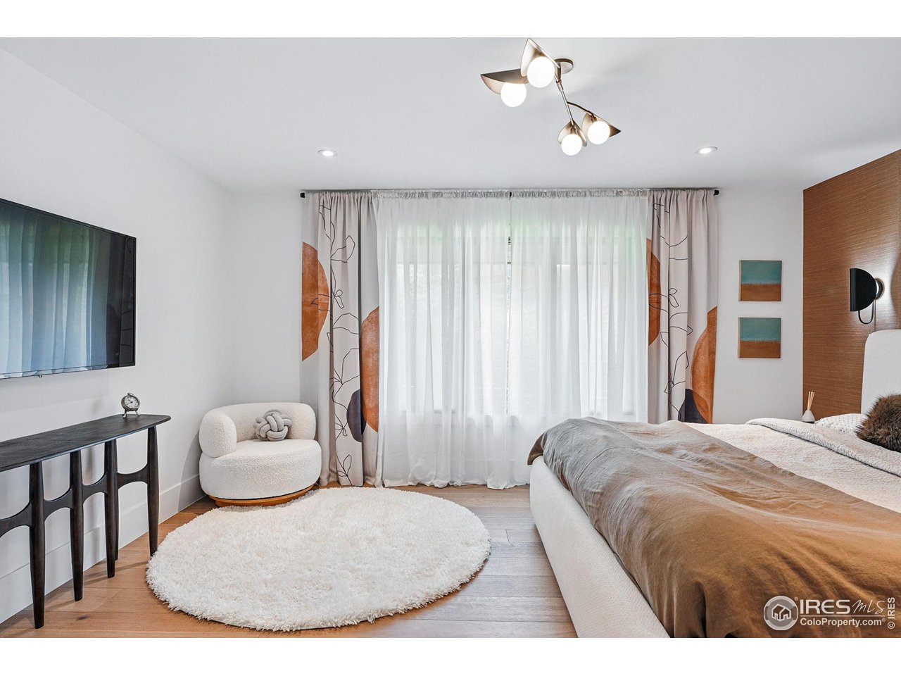 6923 Hunter Place Boulder, CO 80301 - Photo 16 of 34 a bedroom with a bed a couch and a chandelier